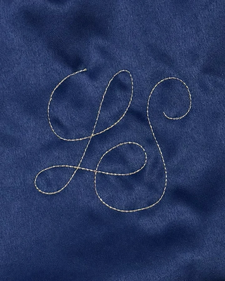 Monogramme LS brodé en calligraphie sur le satin marine d'un Knot Bag